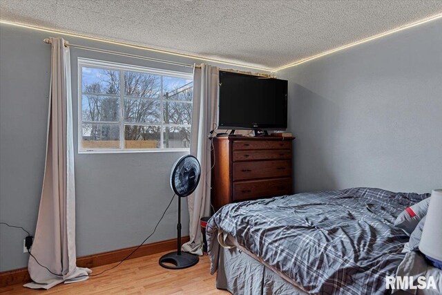 bedroom with wood-type flooring and a textured ceiling