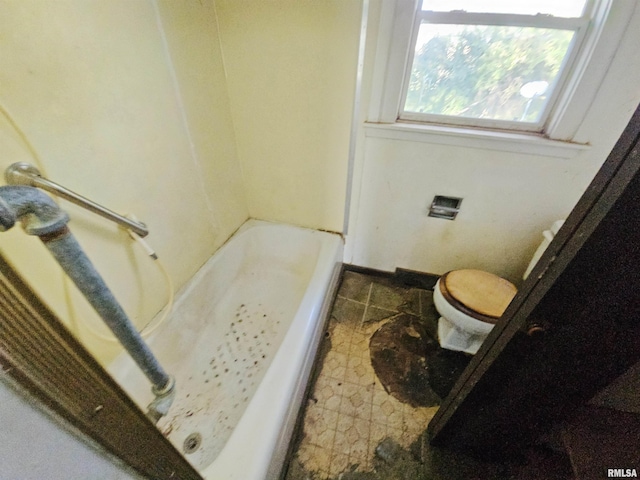 bathroom with a washtub and toilet