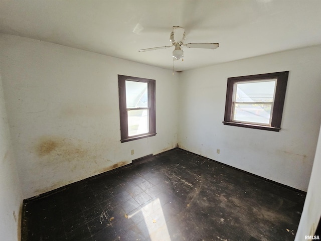 unfurnished room with ceiling fan and a healthy amount of sunlight