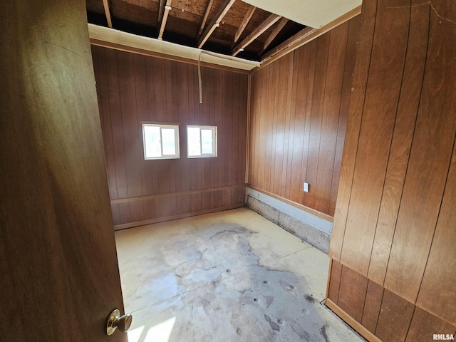 spare room featuring wood walls and concrete floors