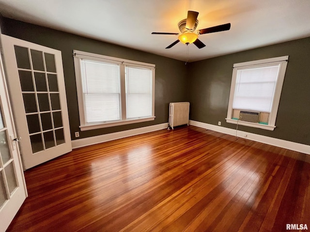 spare room with hardwood / wood-style floors, ceiling fan, cooling unit, and radiator