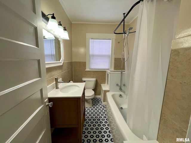 full bathroom featuring crown molding, toilet, shower / bath combo with shower curtain, vanity, and tile walls