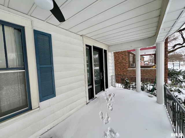 snow covered patio featuring covered porch and ceiling fan