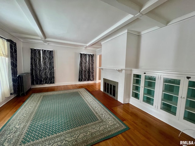 interior space featuring beamed ceiling, radiator heating unit, coffered ceiling, and hardwood / wood-style floors