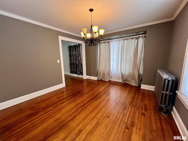 spare room with a chandelier, radiator heating unit, hardwood / wood-style flooring, and ornamental molding