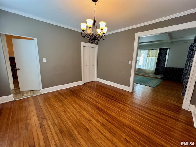 empty room with beam ceiling, hardwood / wood-style floors, a chandelier, and ornamental molding