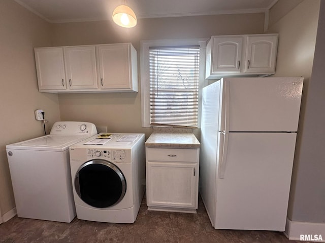 washroom featuring crown molding, washer and clothes dryer, and cabinets