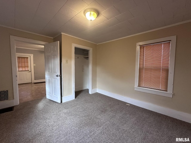 unfurnished bedroom featuring dark carpet and ornamental molding