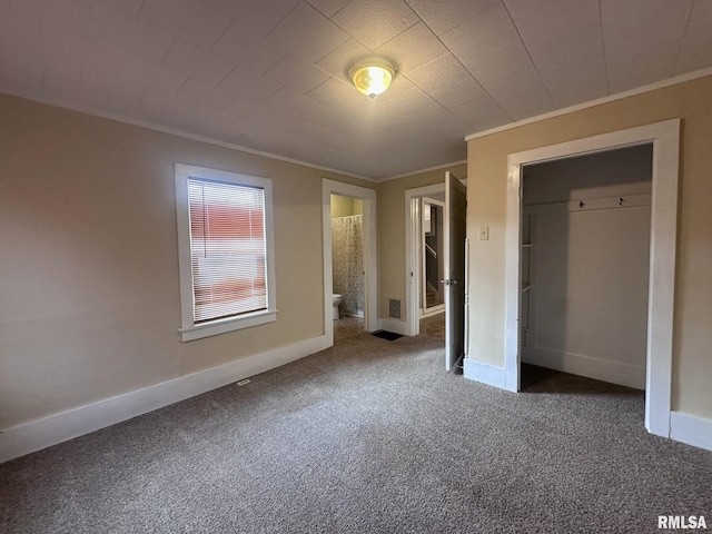 unfurnished bedroom featuring carpet floors, ensuite bath, a closet, and crown molding