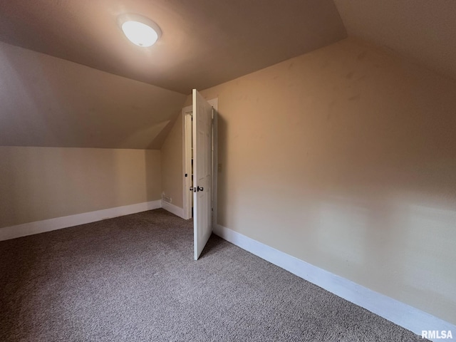 additional living space featuring carpet floors and vaulted ceiling