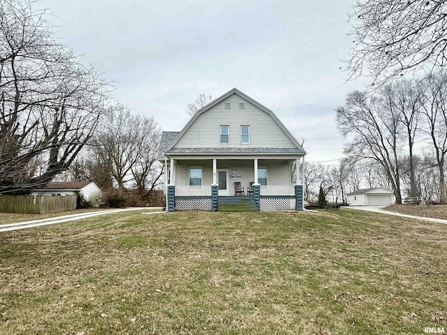 view of front of house featuring a porch, a garage, an outbuilding, and a front yard