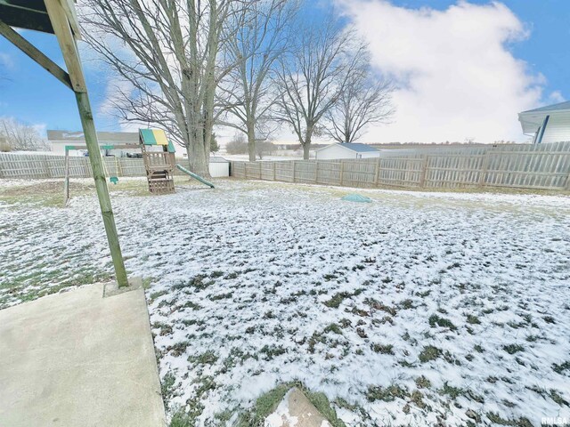 yard layered in snow featuring a playground