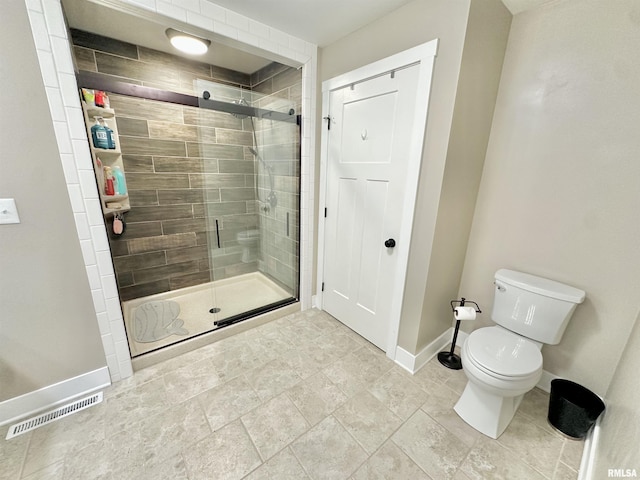 bathroom featuring an enclosed shower and toilet