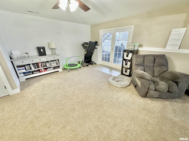 living area featuring carpet, french doors, and ceiling fan