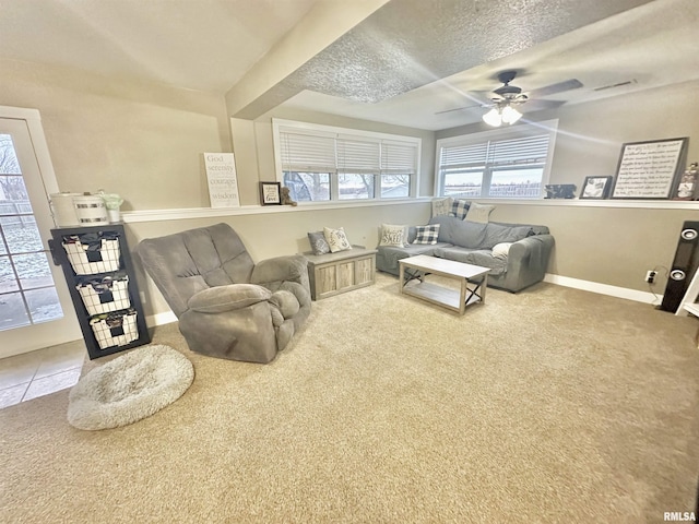 carpeted living room featuring ceiling fan and a textured ceiling