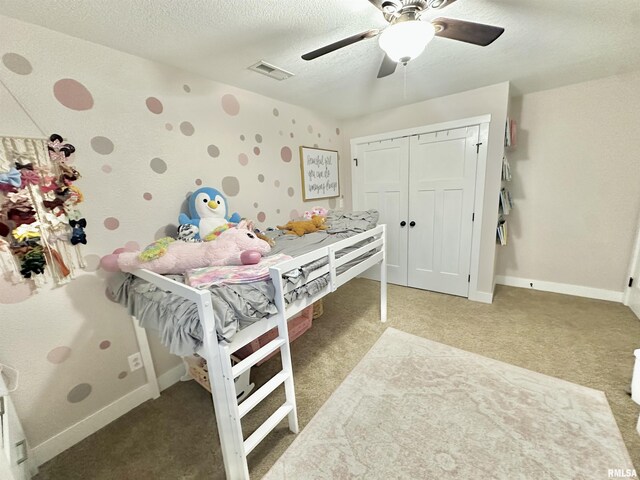 carpeted bedroom featuring a textured ceiling and ceiling fan