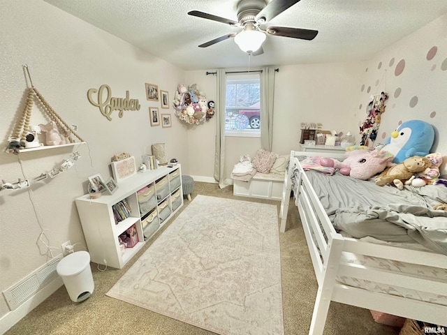 carpeted bedroom featuring ceiling fan and a textured ceiling