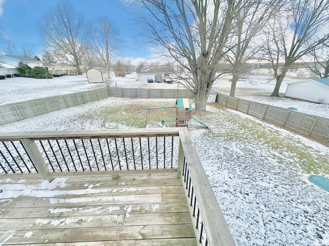 snow covered deck featuring a storage shed