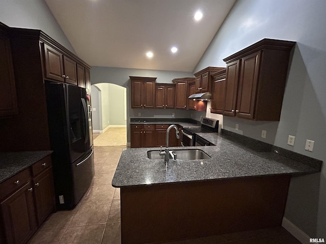 kitchen featuring light tile patterned floors, black refrigerator, lofted ceiling, stainless steel electric range, and sink