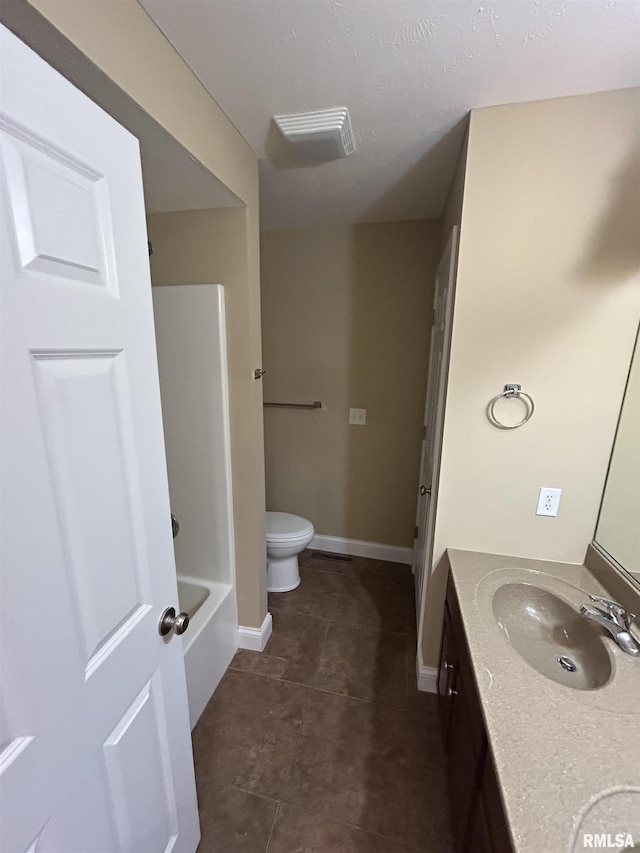 bathroom with toilet, vanity, and tile patterned flooring