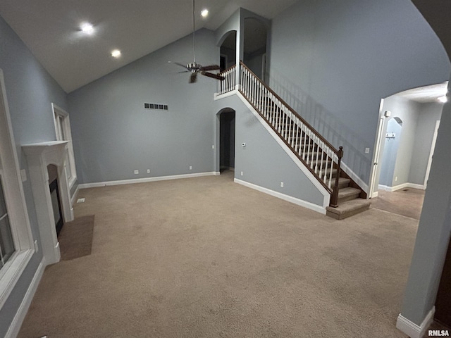 unfurnished living room featuring high vaulted ceiling, light colored carpet, and ceiling fan