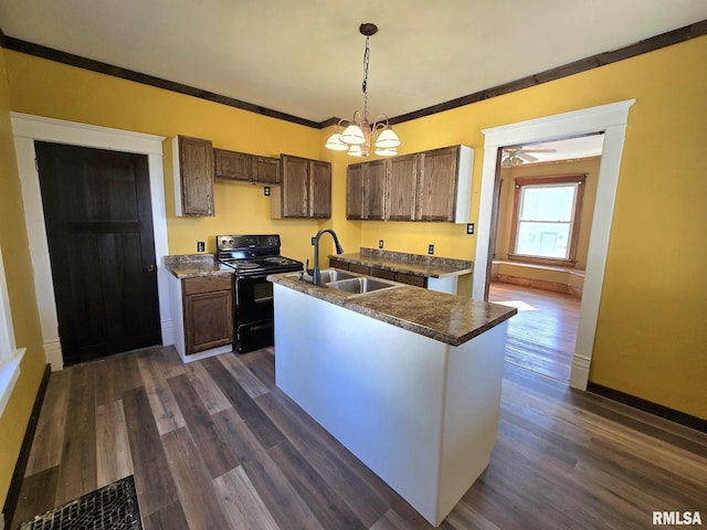 kitchen with sink, black range with electric cooktop, dark hardwood / wood-style flooring, pendant lighting, and a kitchen island with sink