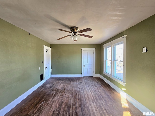 empty room with ceiling fan and dark wood-type flooring