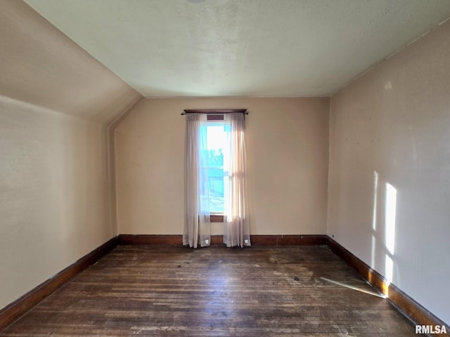 bonus room with dark hardwood / wood-style floors and lofted ceiling