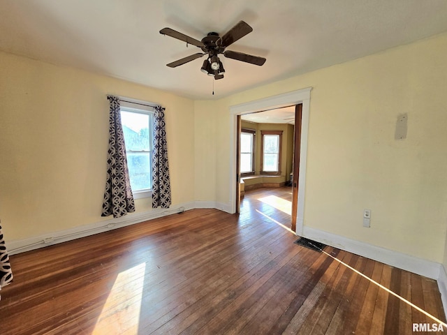 unfurnished room with ceiling fan, dark hardwood / wood-style flooring, and plenty of natural light