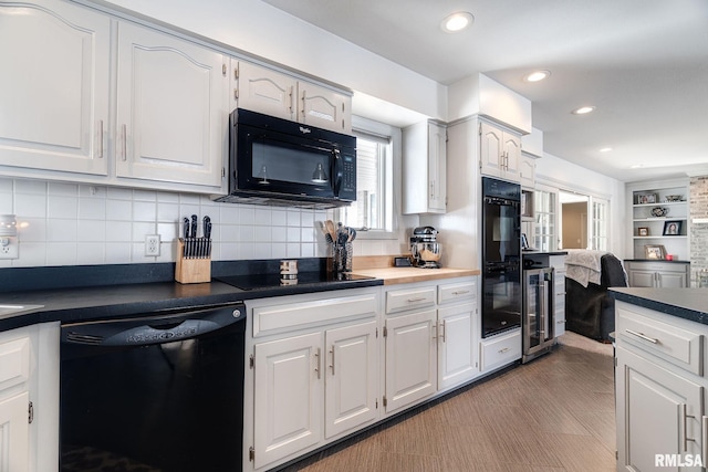 kitchen with white cabinets, tasteful backsplash, and black appliances