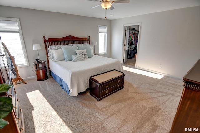 carpeted bedroom featuring multiple windows, a spacious closet, a closet, and ceiling fan