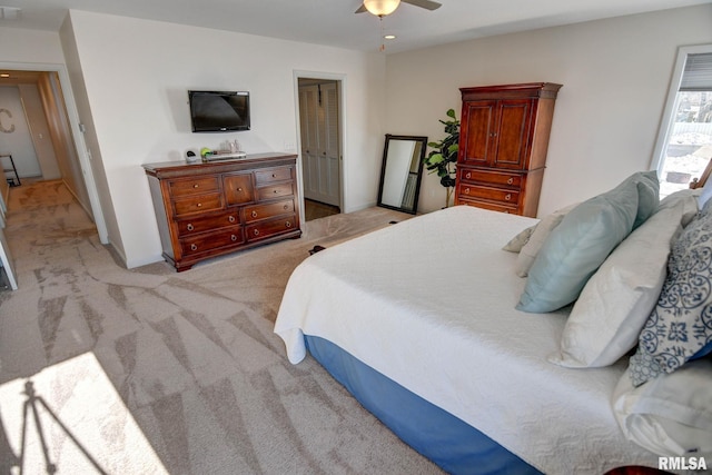 bedroom featuring ceiling fan, light carpet, and a closet