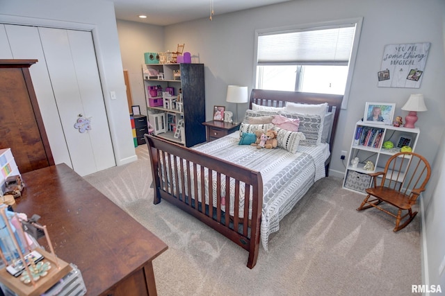 bedroom featuring light carpet and a closet