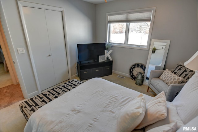 bedroom featuring light colored carpet and a closet