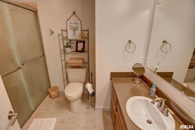 bathroom with tile patterned floors, vanity, toilet, and a shower with shower door