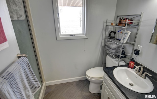 bathroom with vanity, a shower with shower door, and toilet