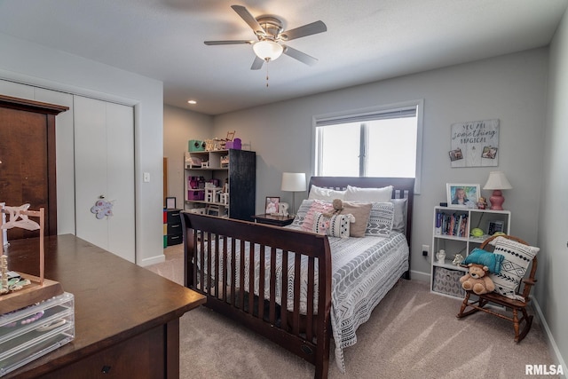 bedroom featuring ceiling fan, light carpet, and a closet