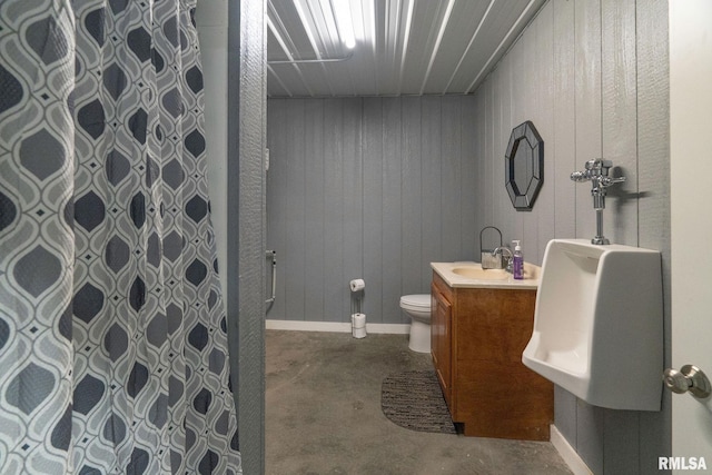 bathroom with a shower with shower curtain, vanity, toilet, and concrete floors