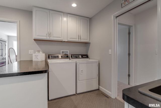 laundry room with washer and clothes dryer and cabinets