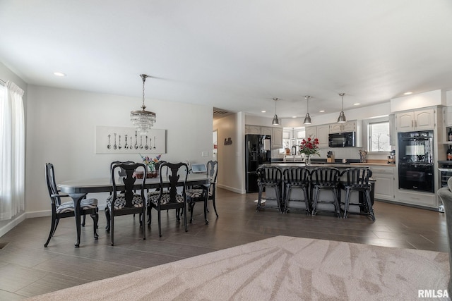 tiled dining area featuring a notable chandelier and plenty of natural light