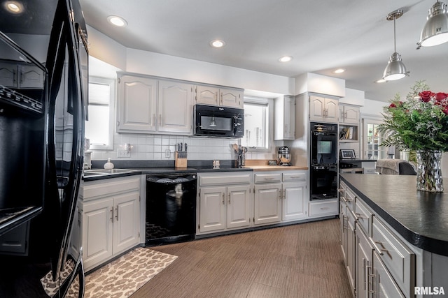 kitchen featuring decorative backsplash, white cabinetry, sink, and black appliances