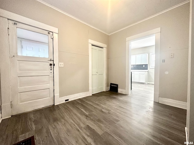 foyer entrance with crown molding and dark wood-type flooring