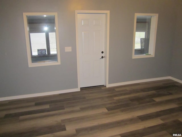 empty room featuring dark hardwood / wood-style flooring and a wealth of natural light