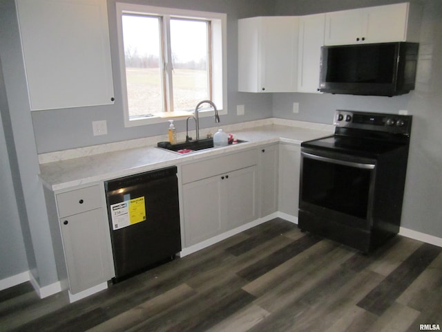 kitchen with black appliances, dark hardwood / wood-style flooring, white cabinets, and sink