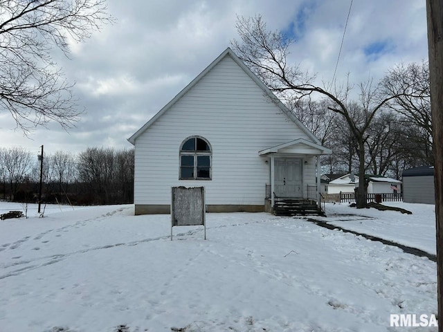 view of snow covered back of property