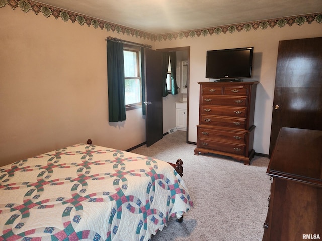 carpeted bedroom featuring ensuite bath