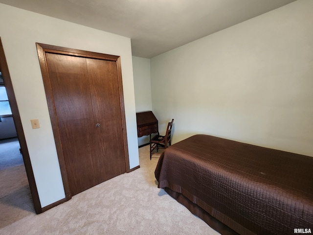 bedroom featuring light colored carpet and a closet