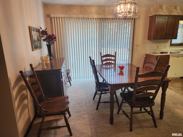 dining room with light carpet and a notable chandelier