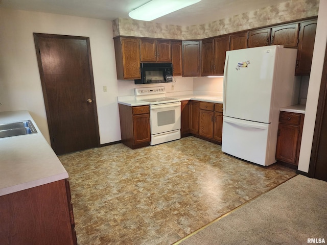 kitchen featuring white appliances, dark brown cabinetry, and sink