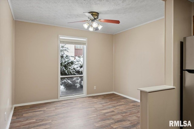 empty room featuring ceiling fan, ornamental molding, hardwood / wood-style floors, and a textured ceiling